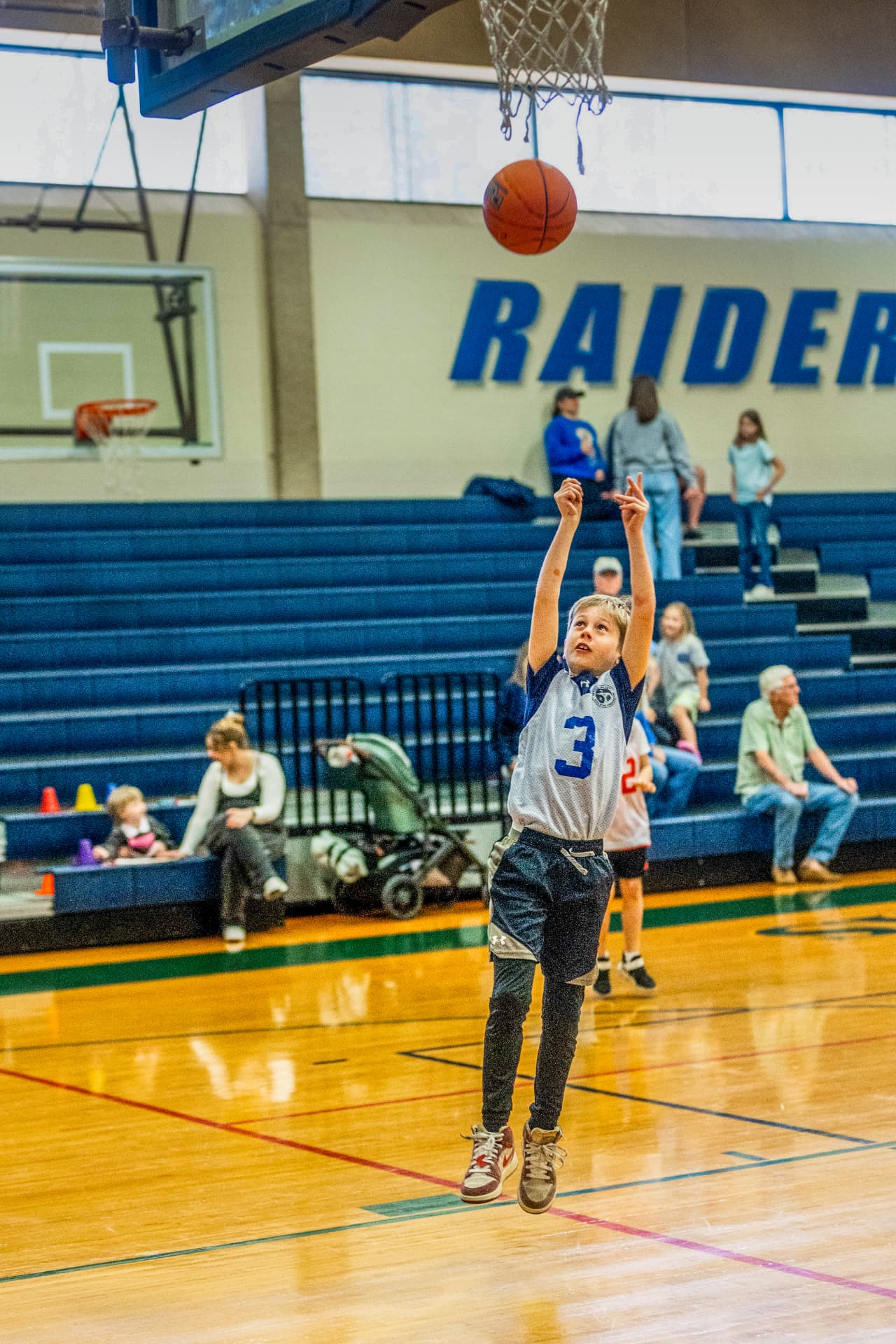 Young basketball player shooting toward the hoop