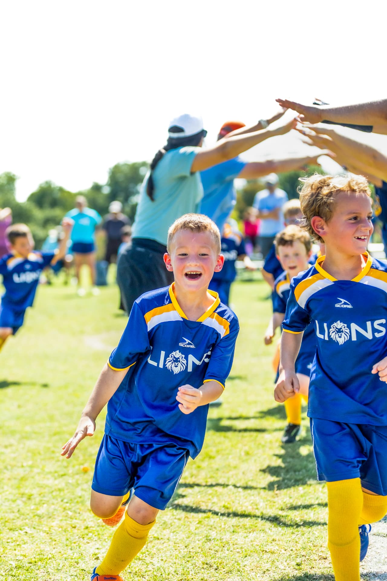 Young soccer players running through a high-five tunnel