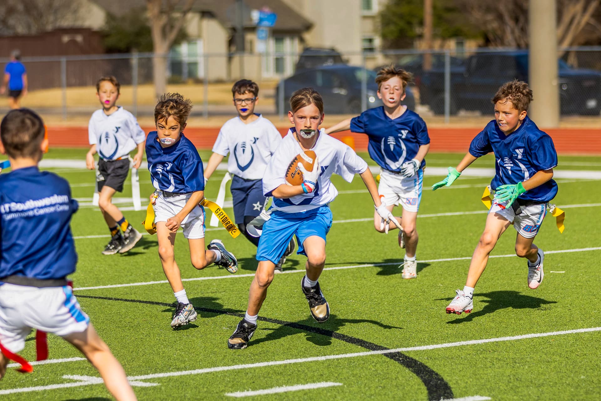 Flag football ball carrier pursued by defenders