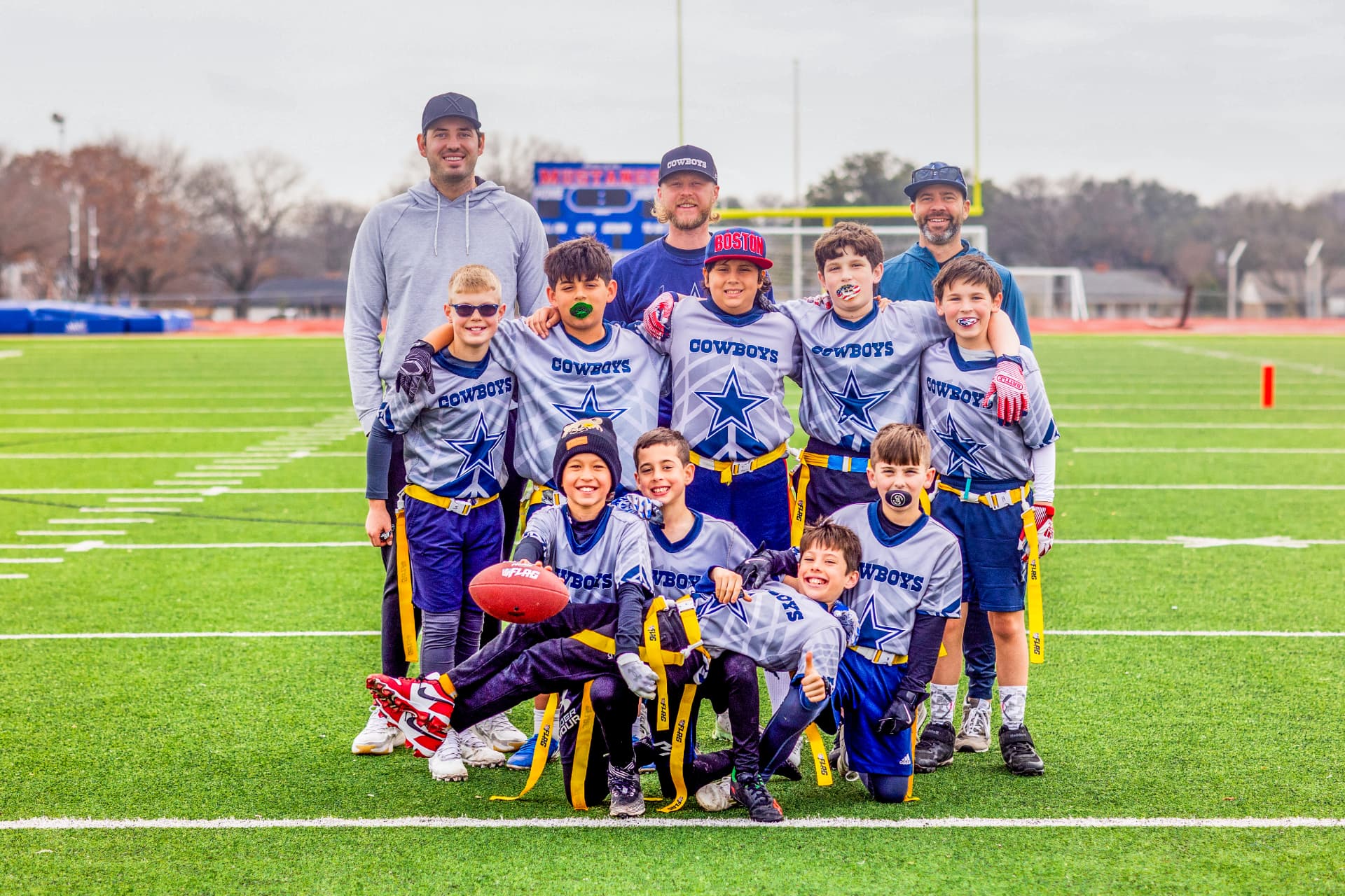 Youth flag football team posing with coaches