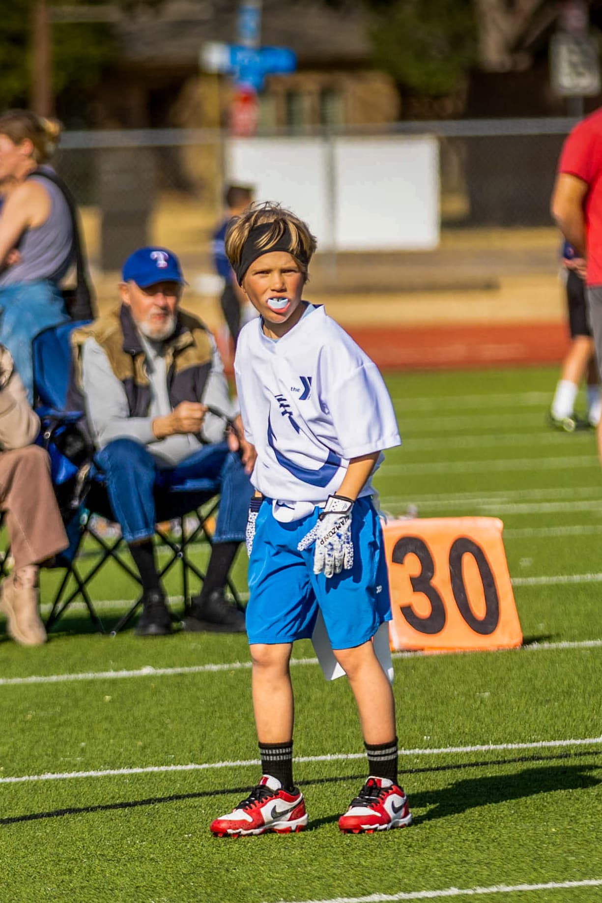 Young flag football player ready on the sideline